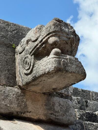 Fotografía de la cabeza del dios Quetzalcoatl esculpida en piedra
